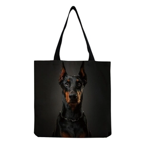 Close-up of a black canvas tote bag featuring a realistic Doberman dog head print