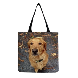 Detail of canvas tote bag featuring a realistic golden retriever print and black straps