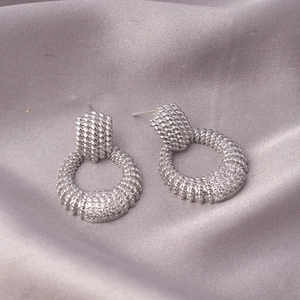 Silver twisted rope hoop earrings with micro-paved zircons on elegant silk fabric