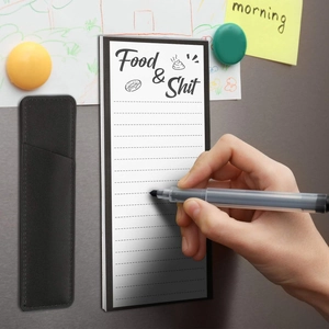 Magnetic notepad set with pen holder and marker on a fridge surface with hand writing