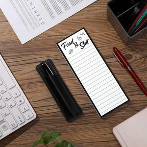 Close-up of minimalist magnetic notepad and black leather pencil case on a wooden desk