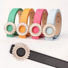 Dettaglio di cinture colorate in ecopelle con fibbie a forma di girasole di strass