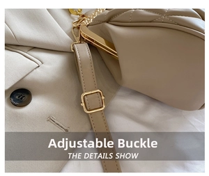 Close-up of golden metal adjustment buckle and quilted leather strap on a beige bag