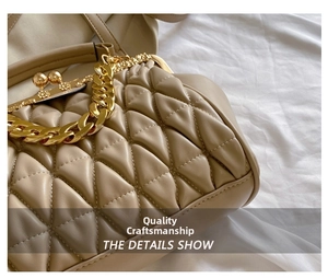 Close-up of beige quilted leather crossbody bag with chain and triangle stitching detail