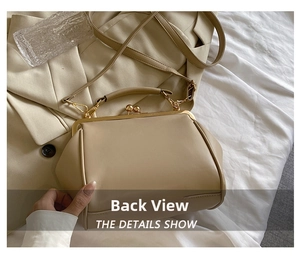 Detail view of the beige vintage crossbody bag back and side texture on a beige suit