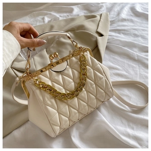 Detail of cream quilted crossbody bag with vintage gold clasp and elegant chain strap