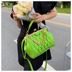 Detail of neon green quilted handbag with vintage gold metal frame and chain strap