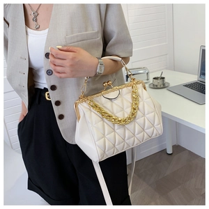 Detail of white quilted crossbody bag with gold metal frame and dual strap design