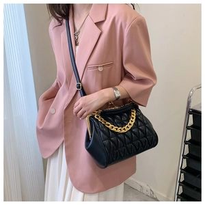 Detail of vintage quilted black handbag with gold chain and metal frame clasp