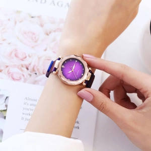 Close-up of elegant rose gold watch with purple gradient dial and rhinestone markers