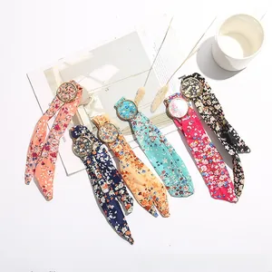 Group of floral silk strap watches in multiple colors shown on a stylish lifestyle background
