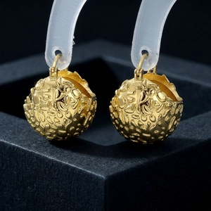 Elegant 18K gold-plated spherical earrings with textured relief on black jewelry box
