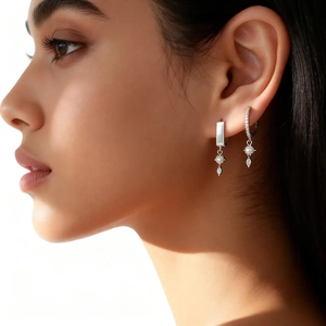 Macro shot of woman wearing s925 silver earrings with pearls and pavé cubic zirconia