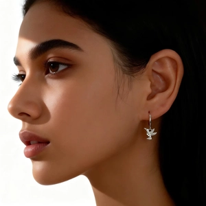Close-up of a model wearing a silver hummingbird earring with sparkling pavé crystals