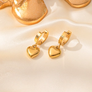 Boucles d'oreilles cœur dorées 18K poli pour femmes sur fond élégant en satin