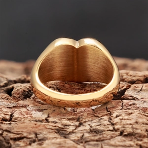 Vue macro détaillée d'une bague large plaquée or avec une texture intérieure en métal brossé