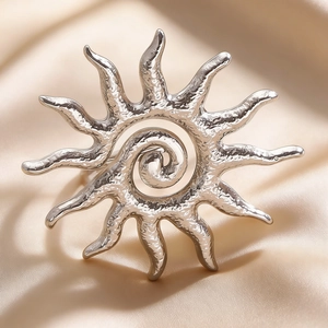 Detailed macro view of silver sun pendant with hammered texture on champagne silk
