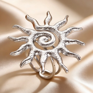 Detail of silver sunburst pendant with textured metal finish on champagne satin fabric