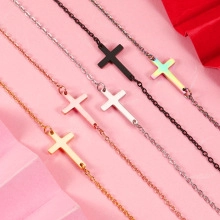 Detail showing five stainless steel cross necklaces in gold, silver, rose gold, and black