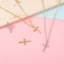 Detail of cross pendant necklace set with cubic zirconia in gold and silver finish