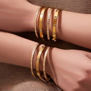 Stack of gold PVD plated stainless steel bangles with zircon inlay and etched patterns