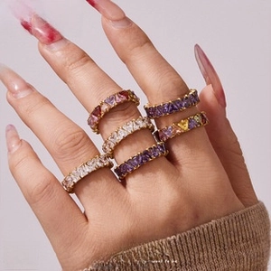 Close-up of heart-cut cubic zirconia rings in multiple colors on a model's hand