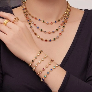 Detailed view of layered 18K gold plated jewelry set with colorful round gemstones