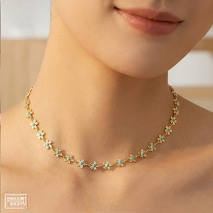 Detail of 18k gold plated ginkgo leaf bracelet with turquoise beads on model neck