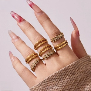 Detailed close-up of 6-piece 18K gold plated ring set with leaf designs on a hand