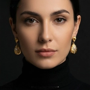 Detail of vintage teardrop earrings with central pearl and sparkling starburst pattern