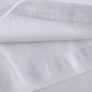 Detailed close-up of precise overlock stitching on the hem of a white cotton T-shirt