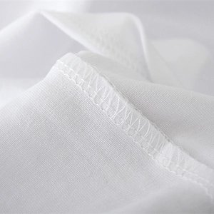Close-up of premium white cotton knit fabric with high-density overlock stitching