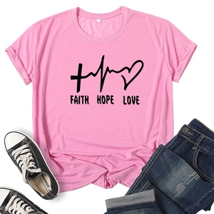 Flat lay of pink cotton T-shirt featuring black Faith Hope Love typography with denim