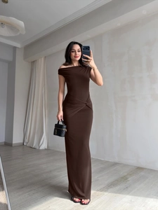 Detail of elegant dark brown off-shoulder maxi dress showing twisted waist ruching fabric
