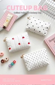 Detailed view of quilted coin purses with heart and polka dot patterns on a lifestyle desk