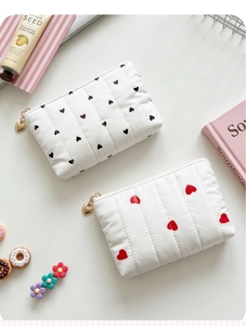 Detail of quilted heart pattern pouches with stylish golden heart-shaped metal zippers