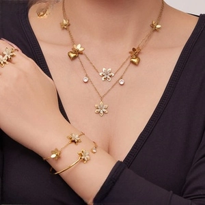 Close-up of gold layered necklace set with heart charms and sparkling zircons