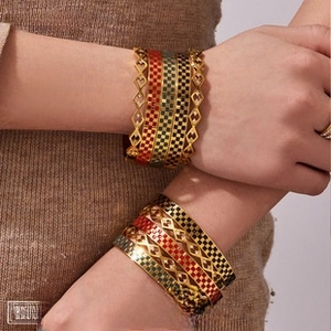 Stack of gold-plated bracelets featuring colorful checkerboard and hollow patterns
