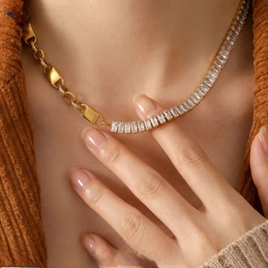 Detail view of a gold chain necklace with rectangular crystals and flat metal links