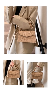 Detail of beige shoulder bag with embossed lotus and koi fish patterns and woven handle