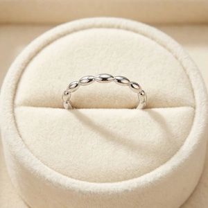 Minimalist silver steel rice grain ring displayed in a premium velvet jewelry box