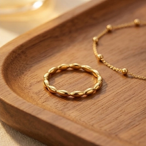 18k gold plated titanium steel rice bead ring and bracelet set on a wooden tray