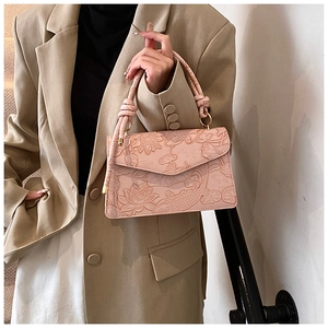 Close-up of pink embossed leather handbag with lotus and koi fish patterns