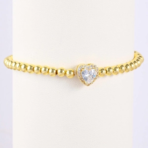 Detail of gold beaded bracelet featuring a heart pendant with sparkling pavé crystals