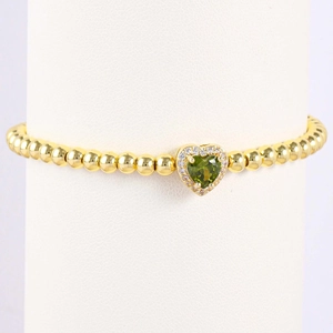 Detail of gold beaded bracelet with heart green gemstone and micro-pave cubic zirconia