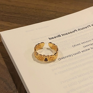 Macro shot of gold hollow-out ring with black gourd pattern on a vintage book
