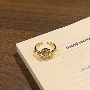 Macro detail of a golden Claddagh ring featuring a heart-shaped zircon on white pages