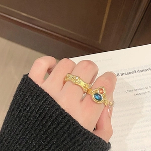 Close-up of baroque gold rings with blue moonstone and intricate crystal accents