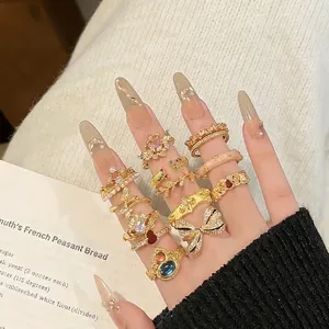 Set of gold rings with butterflies, pearls, and crystals shown in a stylish stack