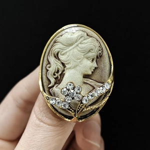 Macro detail of vintage relief brooch with crystal floral accents and golden frame